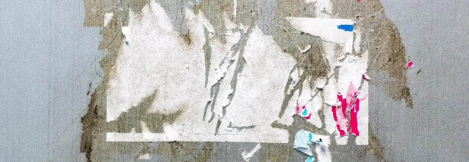 Abgerissene Plakate an Wand